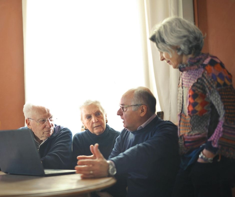 Strasze osoby zgromadzone przy komputerze.
